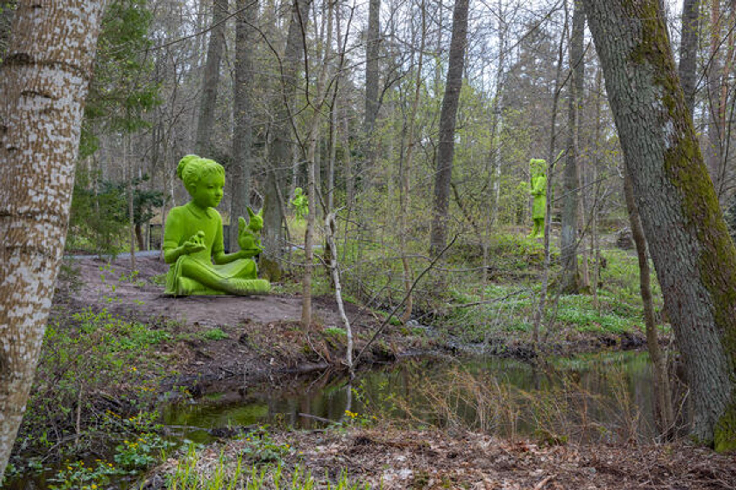 Vihreä lapsiveistos metsässä