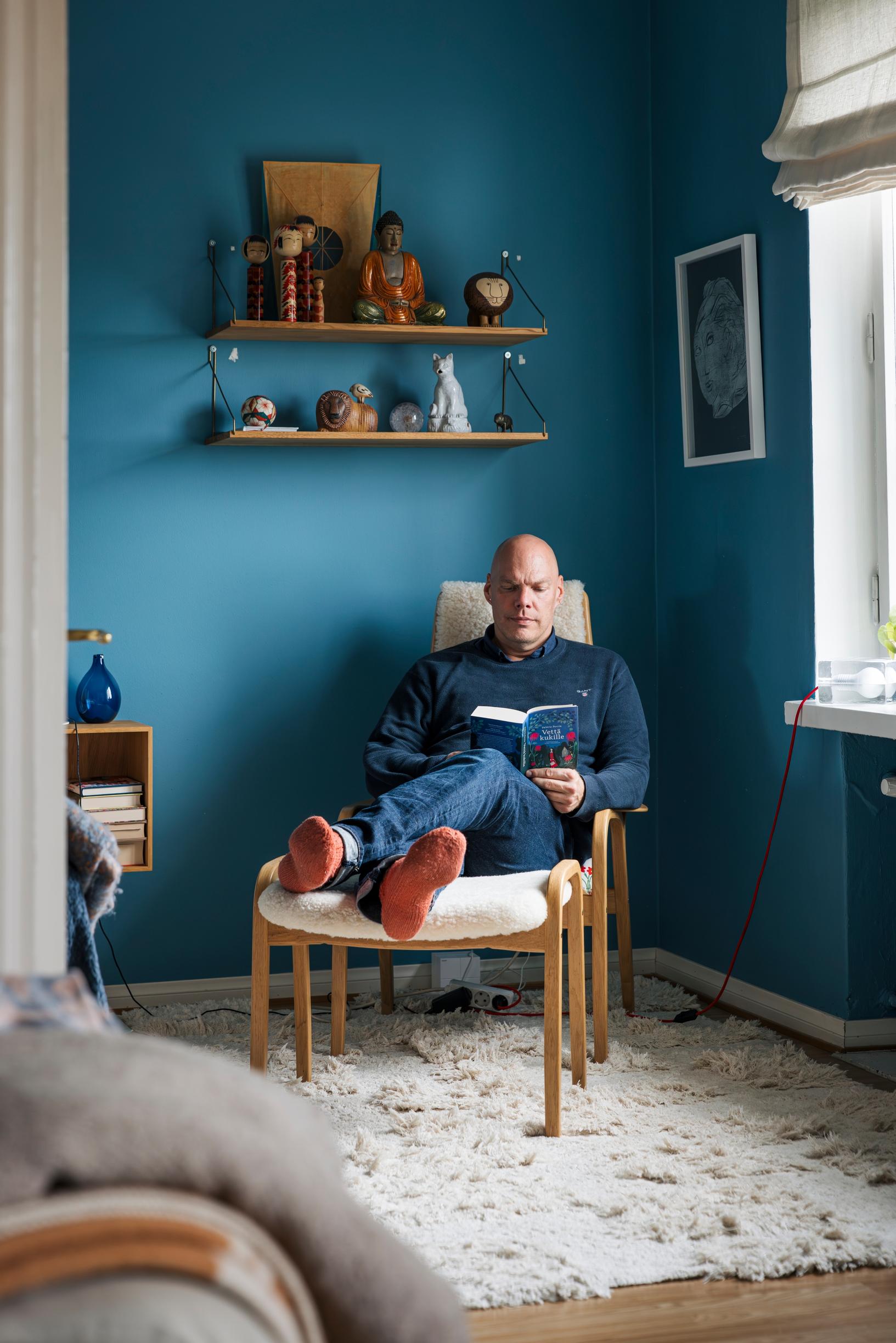 Makuuhuoneen seinän sininen sävy löytyi  Cover Storyn valikoimista. Tuolin yllä on matkamuistohylly.