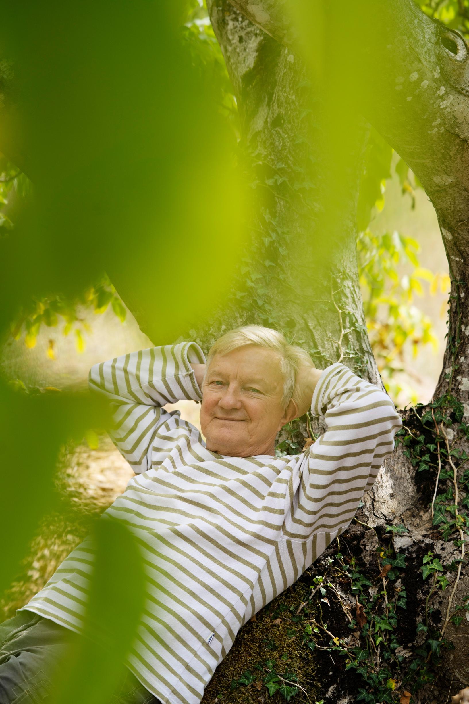 Hannu Väisänen nojailee puunrunkoon