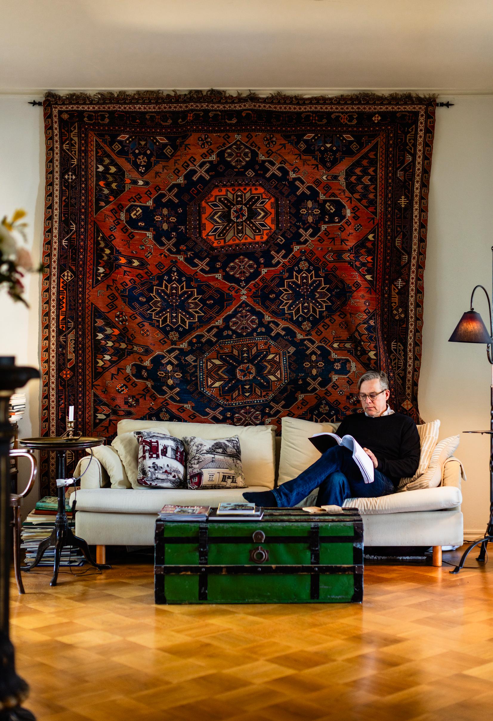 Riko Eklundh opettelee näytelmien vuorosanoja lempipaikallaan olohuoneessa. Riko peri 120 vuotta vanhan seinämaton isän isovanhemmilta, jotka asuivat aikoinaan Bakussa.