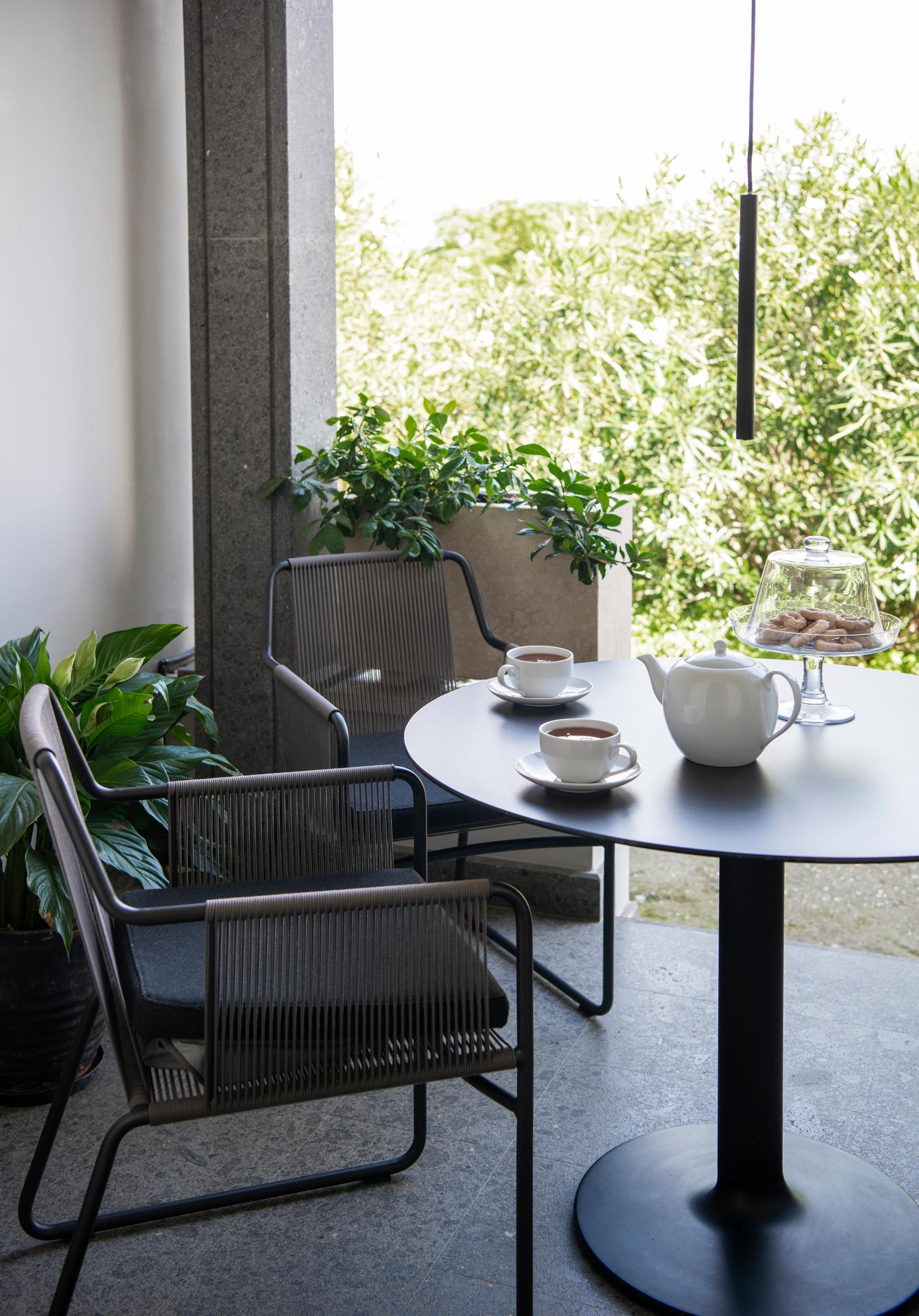 Talon takana aukeava varjoisa terassi sopii rauhallisiin aamuhetkiin. Valaisin on suomalaisen SAS Instrumentsin Tube. Kukkalaatikot on valmistettu travertiinista. 