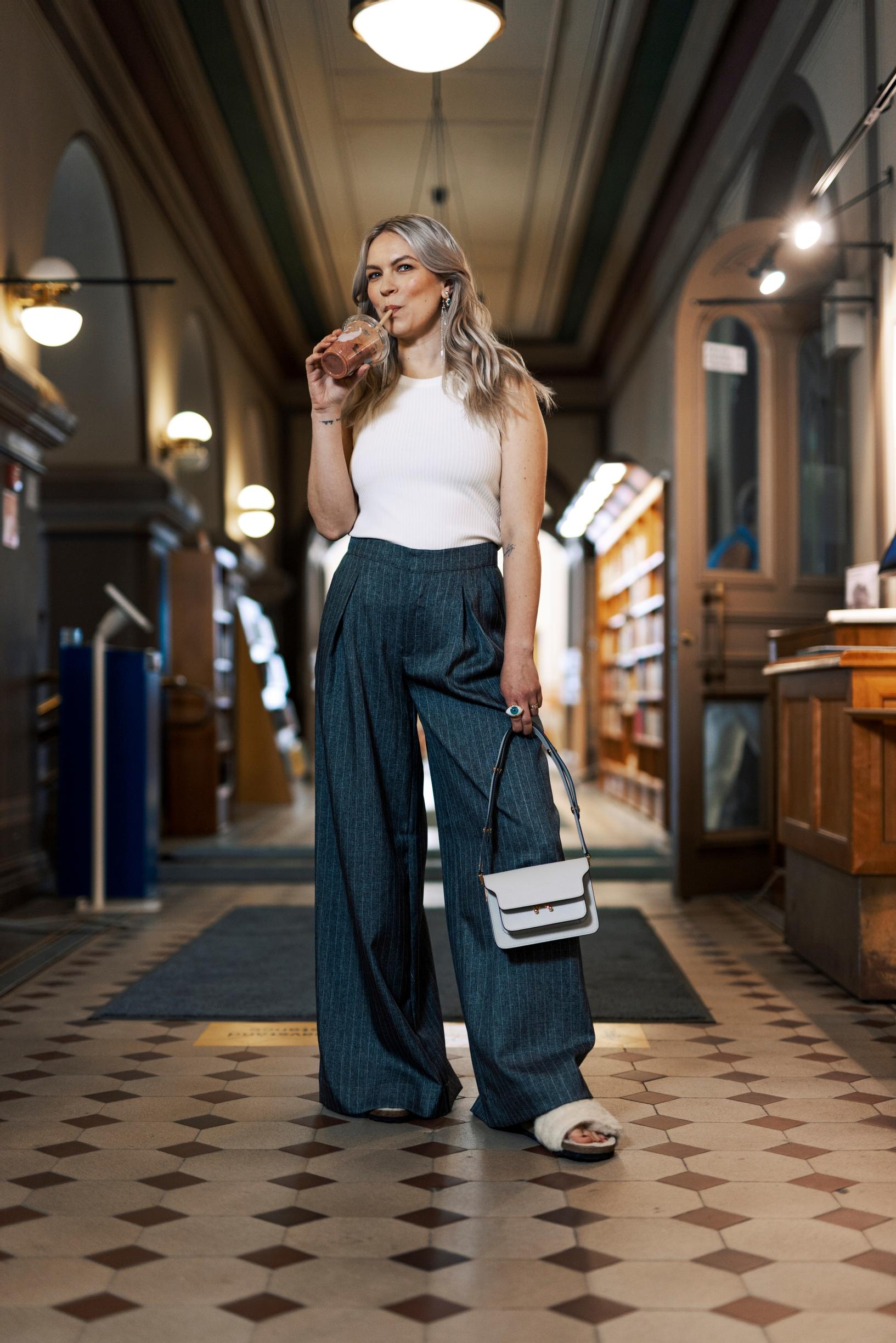 Emmi-Liia Sjöholm on pukeutunut leveälahkeisiin housuihin.