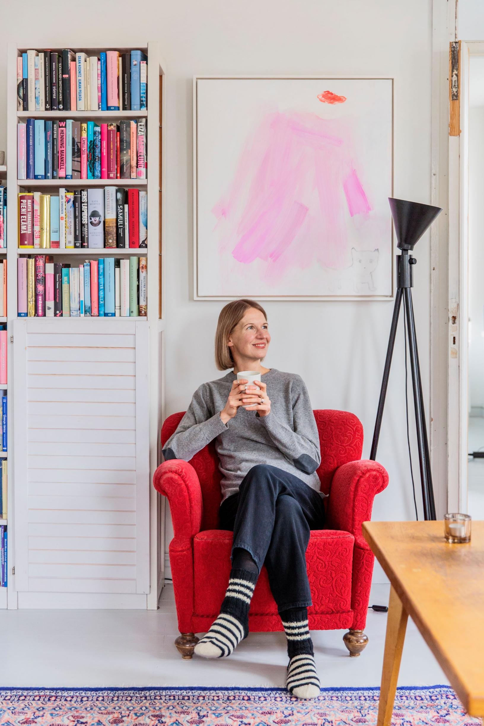 Eskolin istuu punaisessa nojatuolissa, jonka on perinyt isovanhemmilta. Taustalla taulu, jonka Eskolin on saanut nimipäivälahjaksi mieheltään. Taulu on nimeltään Missen kanssa Manhattanilla ja sen on tehnyt Ritva Määttänen-Valkama.