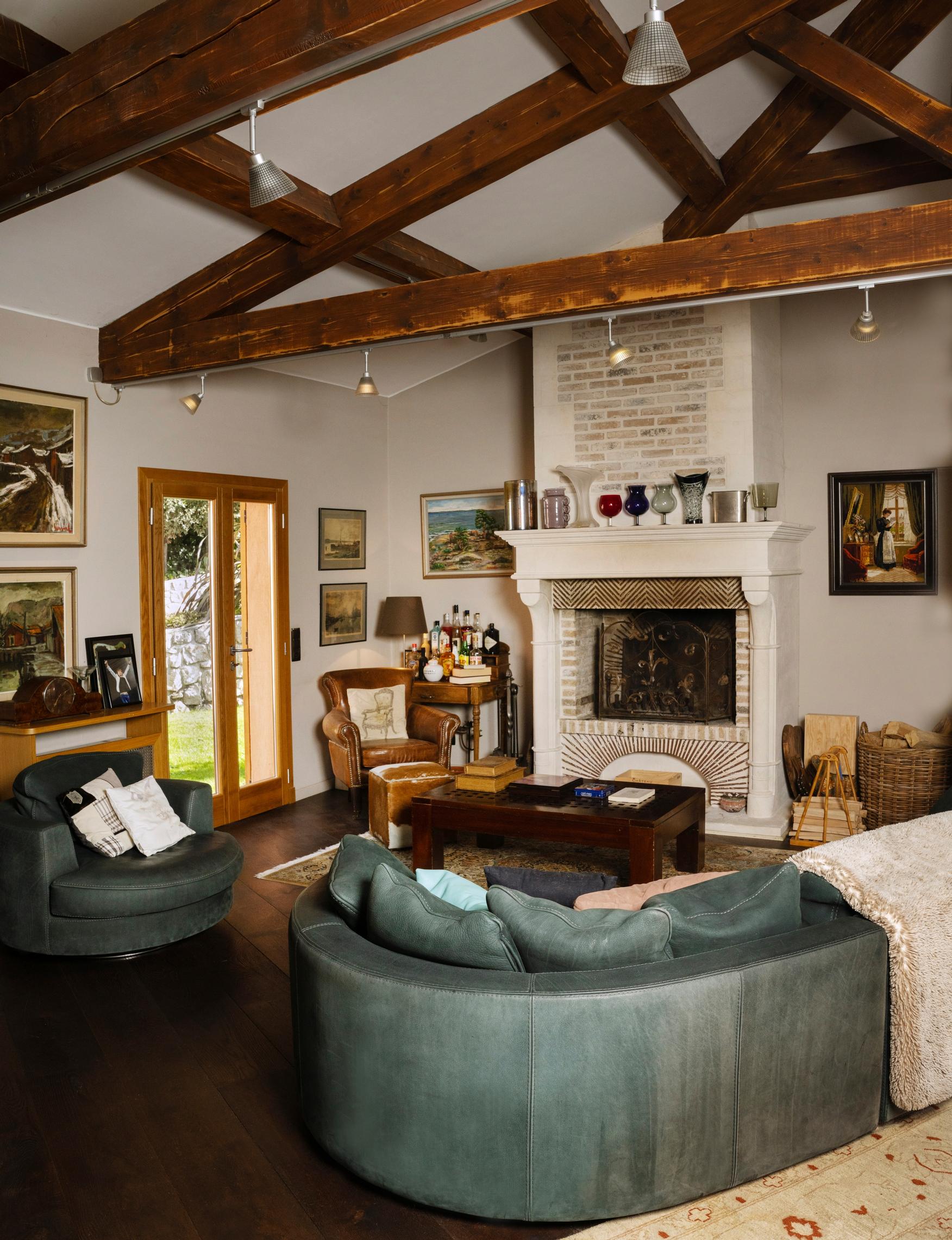 Takan ääressä olevaan vanhaan nahkanojatuoliin on mukava unohtua lukemaan. Tuolin takana on miesystävän lahjoittama rakas taulu. Se kuvaa näkymää Erjan kesäkodin ikkunasta Suomen saaristossa.