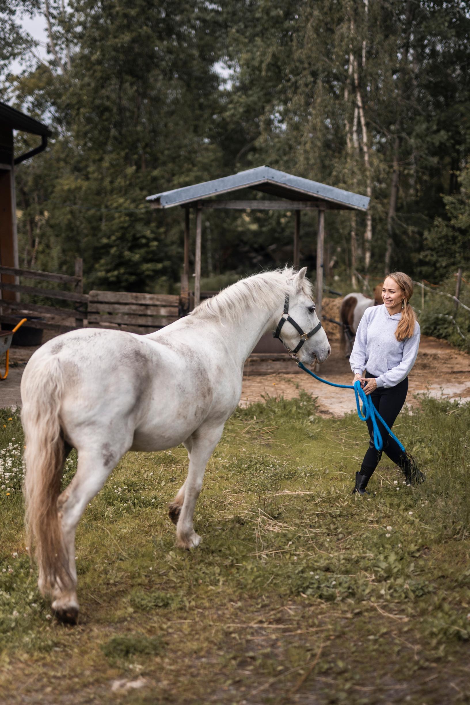 Jenni  valkoisen hevosen kanssa
