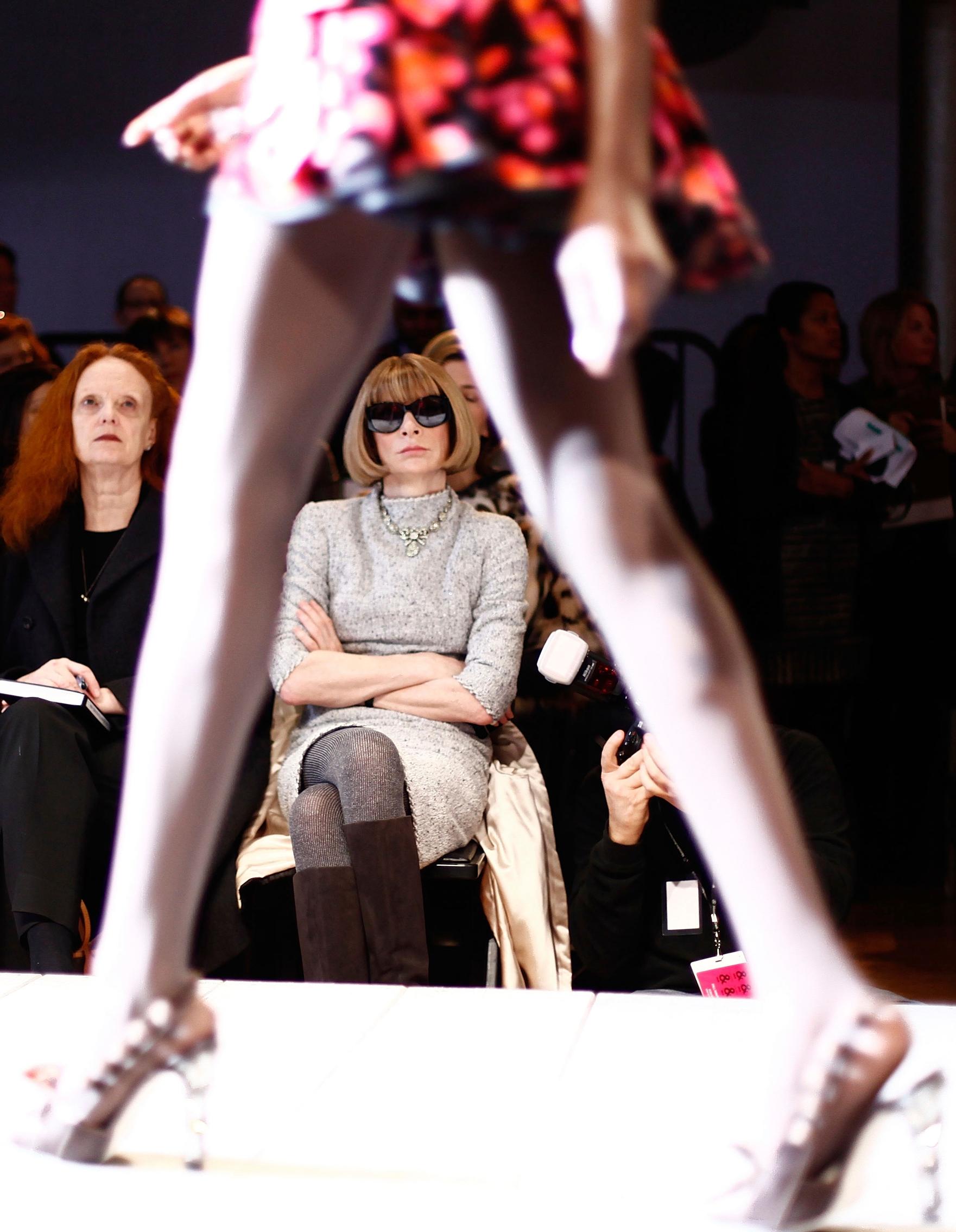Anna Wintour istuu muotinäytöksen katsomossa.