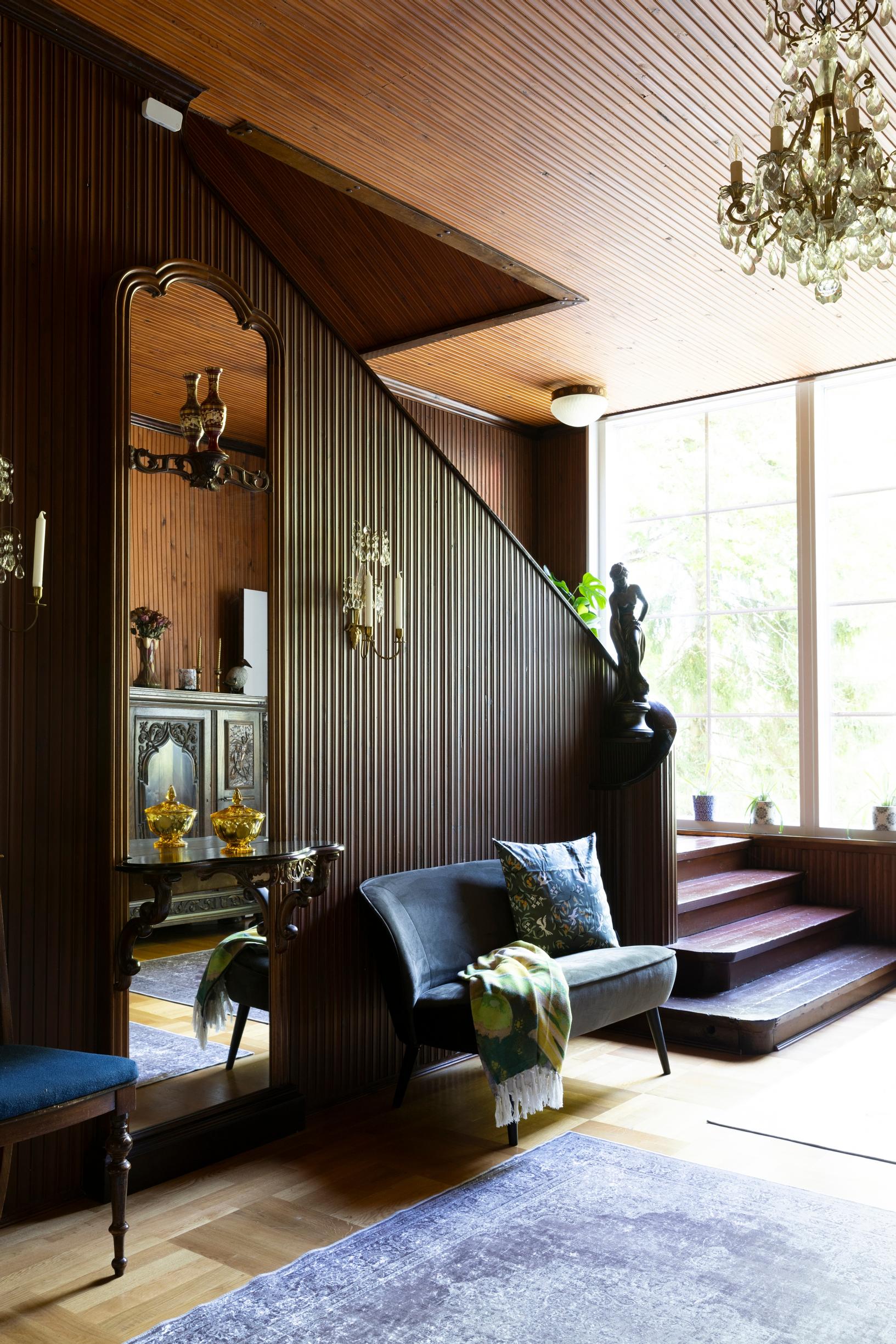 Alakerran eteis­aulassa ja portaikossa on kaunis tumma puu­panelointi, joka muistuttaa talon historiasta. 