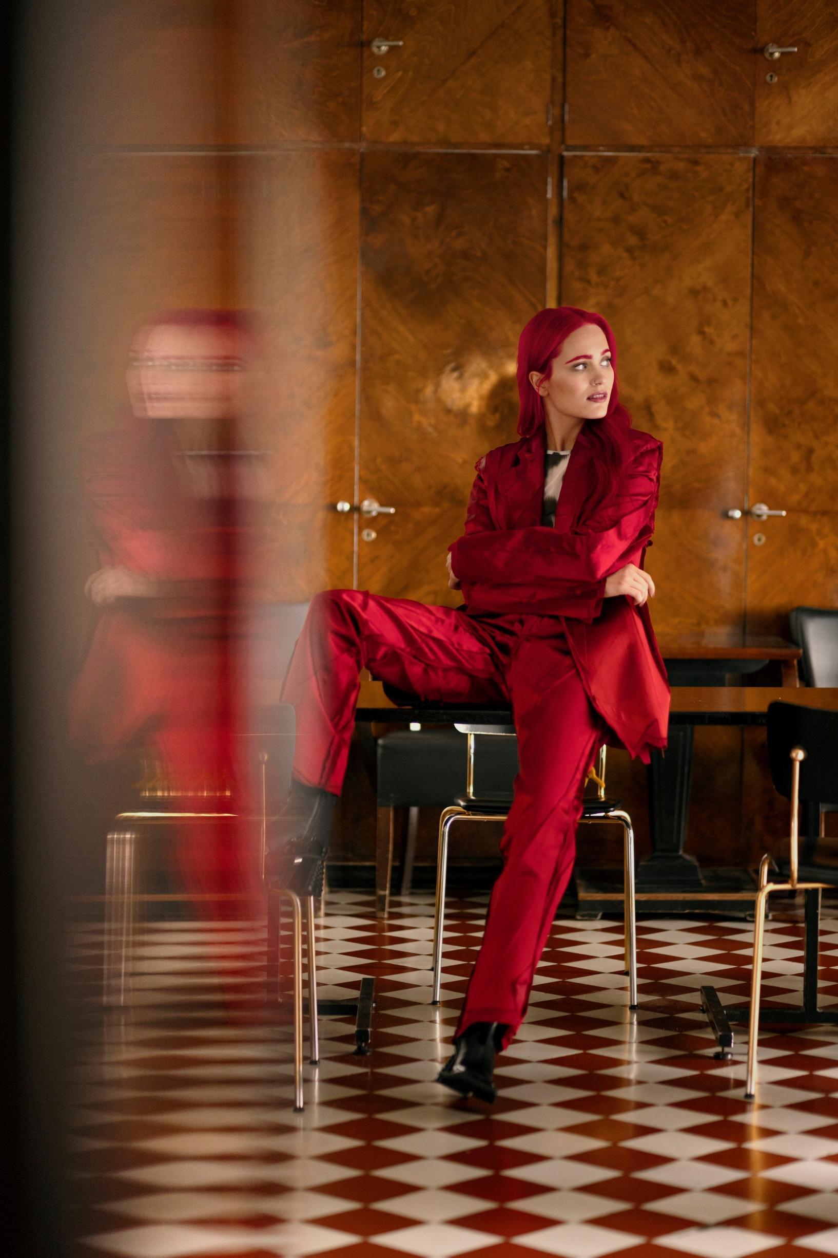 Sanni istuu punaisessa asussa ravintolan salissa.