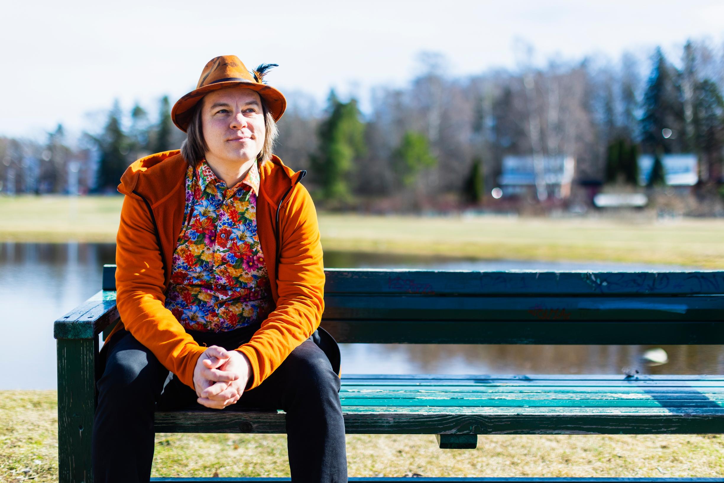 FRank istuu puistopenkillä lamme edessä