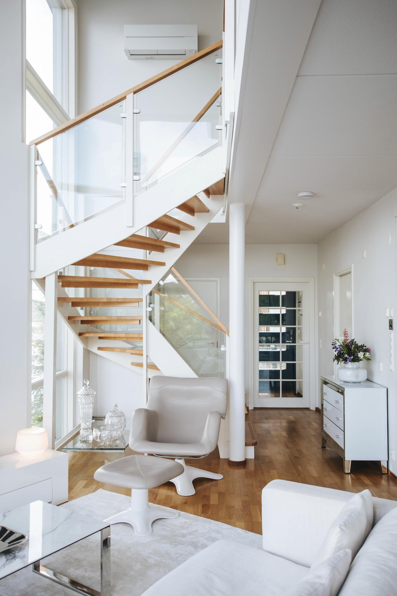 Heti eteisen jälkeen avautuu avara alakerta maisemaikkunoineen. Liisa ja Jarmo arvostavat designia. Järvimaisemaa voi ihastella Yrjö Kukkapuron suunnittelemasta Karuselli-­nojatuolista. Lasikaiteiset portaat vievät yläkertaan, jossa on kaksi makuuhuonetta, sauna ja terassi.