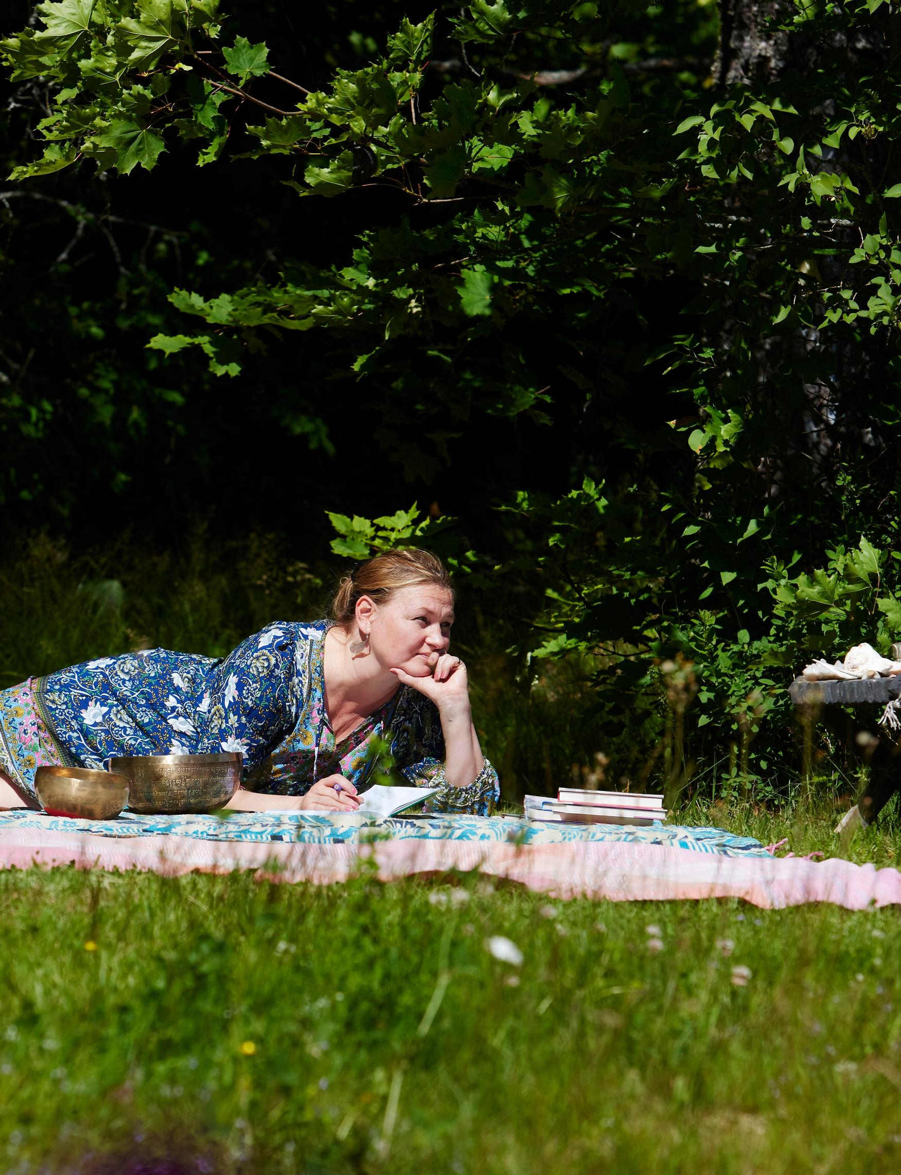 Kauniina kesäpäivinä perhe kokoontuu viltille syreenipensaiden alle.