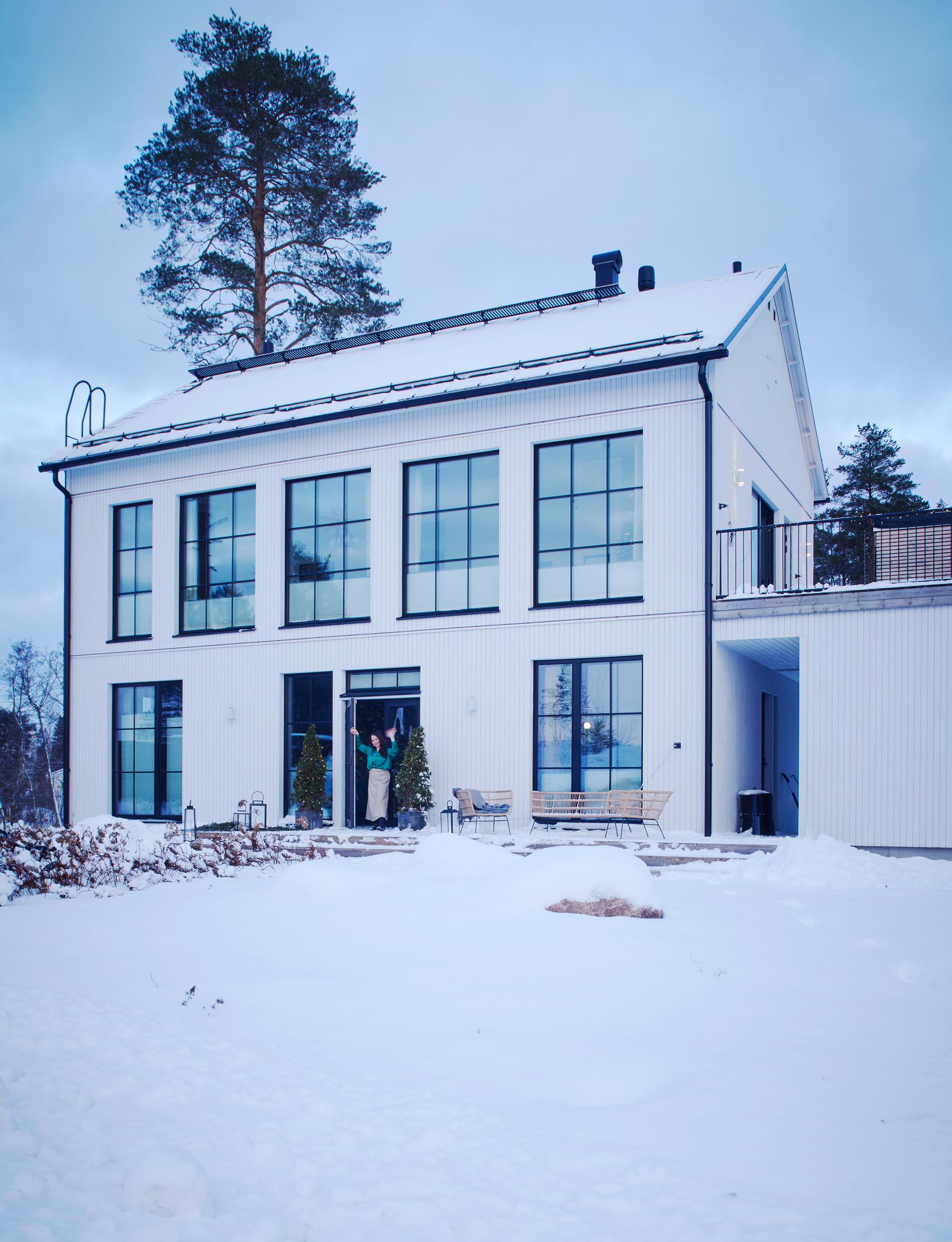 Vaikka talon julkisivu on moderni, perhe halusi siihen myös vanhaa tunnelmaa. Sitä tuovat muun muassa ristikkoikkunat ja pystyverhous.