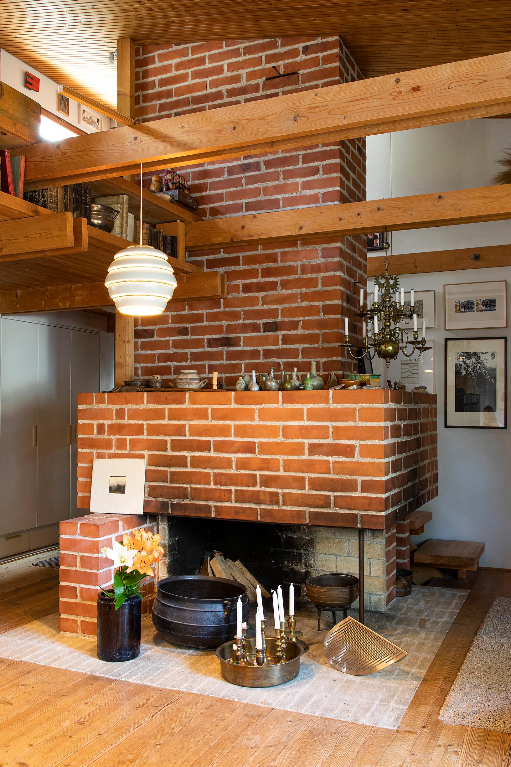 Punatiilitakka hallitsee oleskelutilan päätyä. Sen vierellä näkyy kirkkojen arkkitehtuuria tutkineen isoisän messinkinen kynttiläkruunu. Sen kynttilät sytytetään vain jouluna.