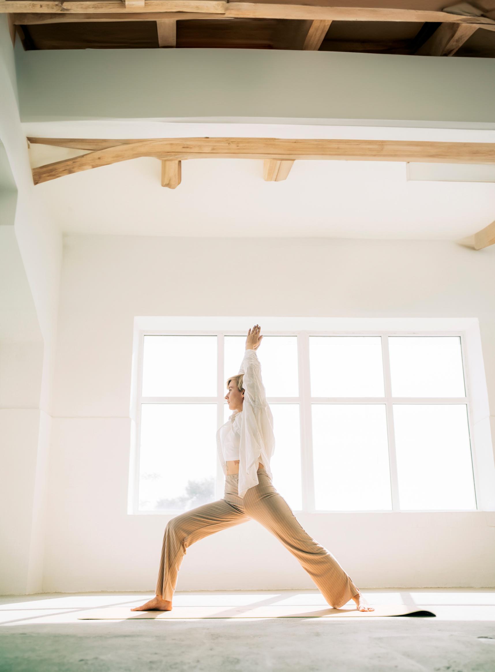 Nainen joogaa ikkunan edessä