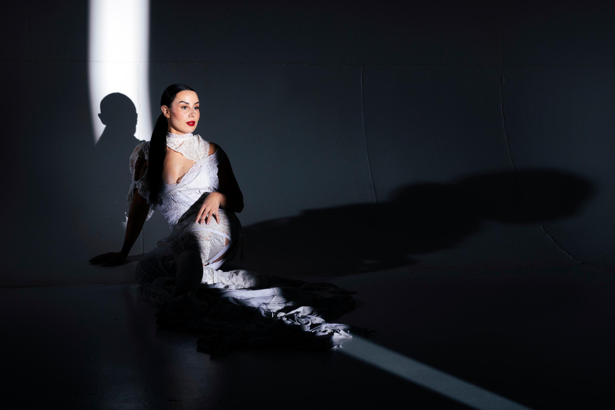 Alma Hätönen istuu maassa.