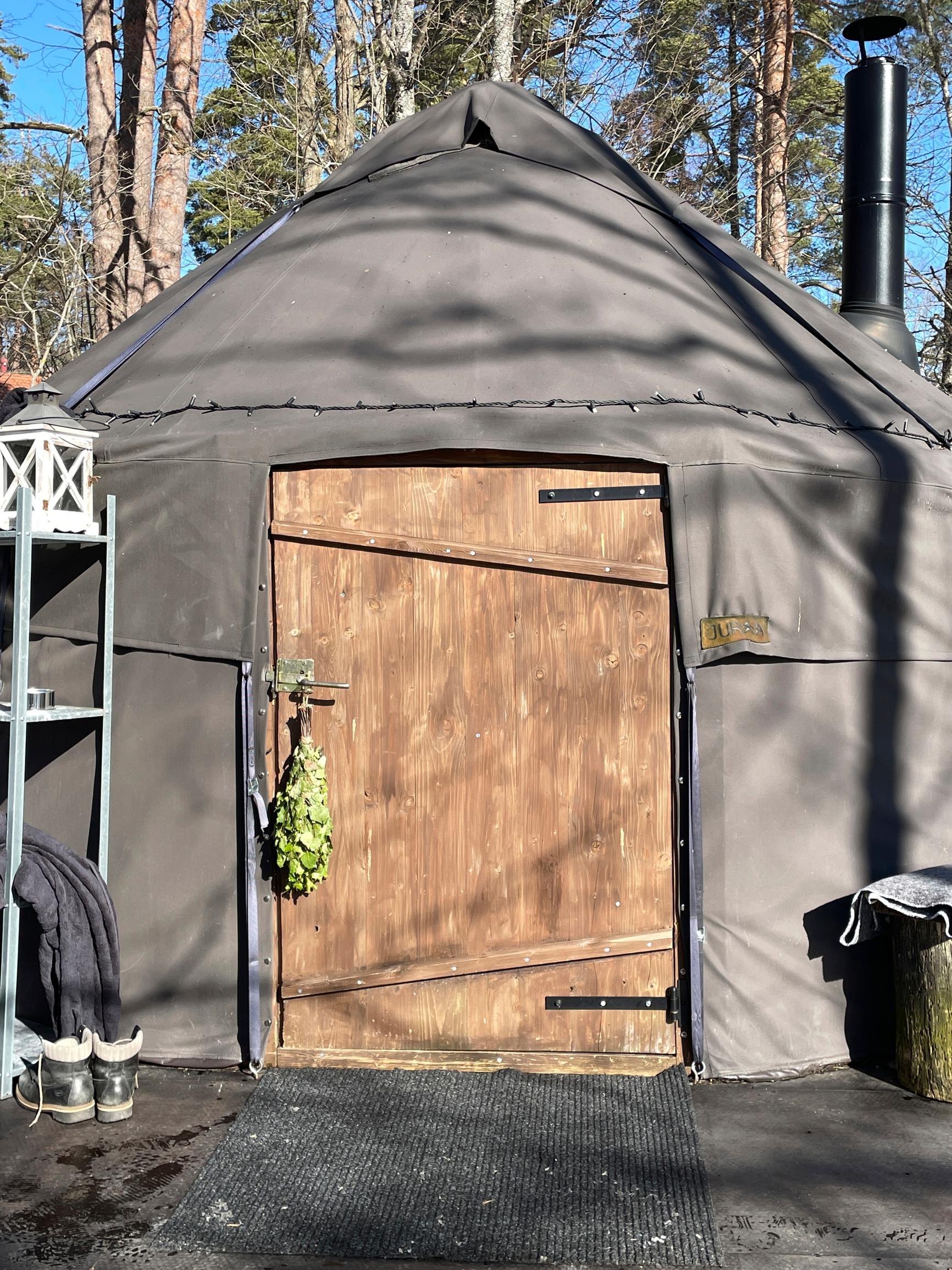 Sauna kevätauringossa, vihta roikkuu ovessa