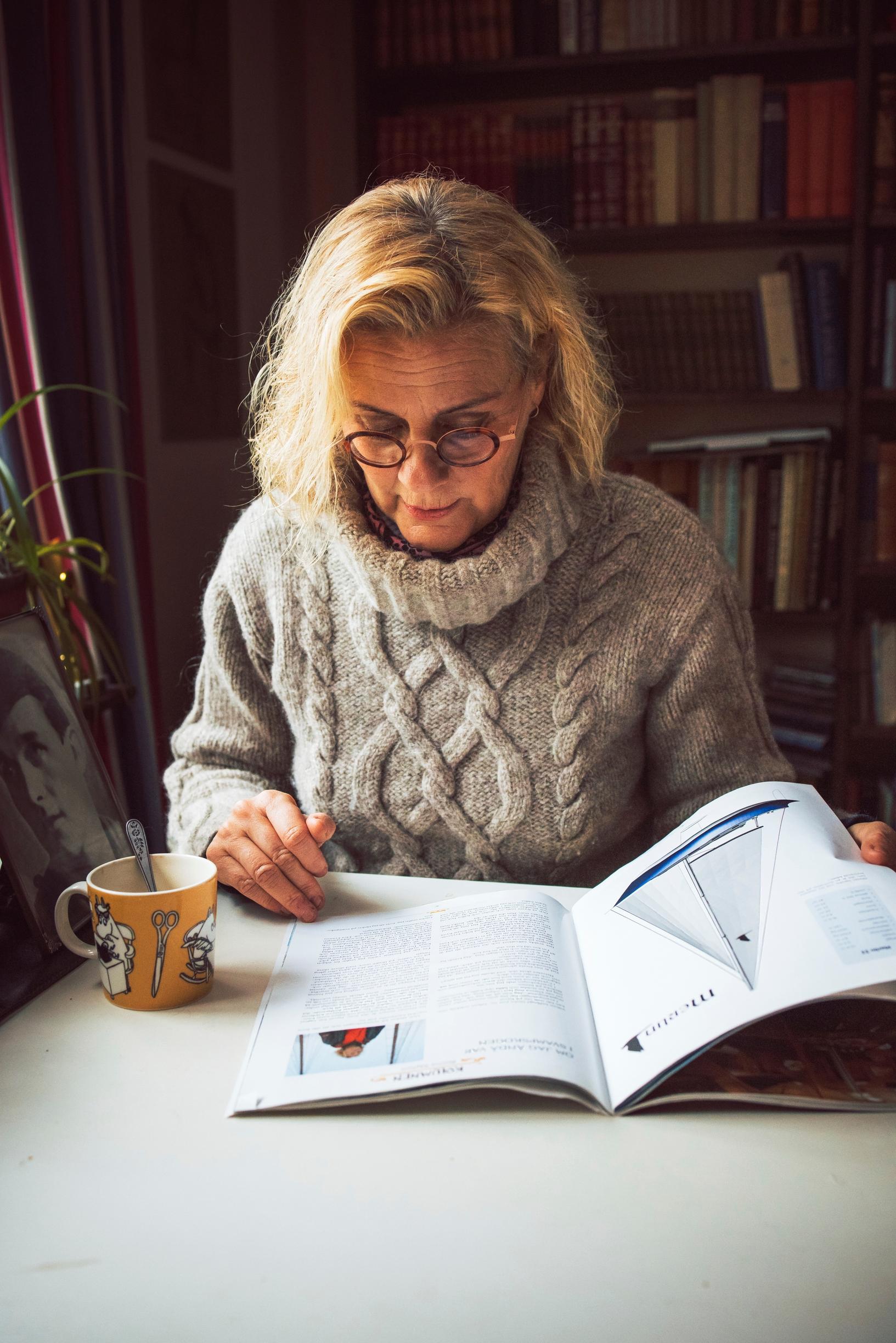 Bettina Sågbom-Ek lukee, päällään itse kudottu villapaita.
