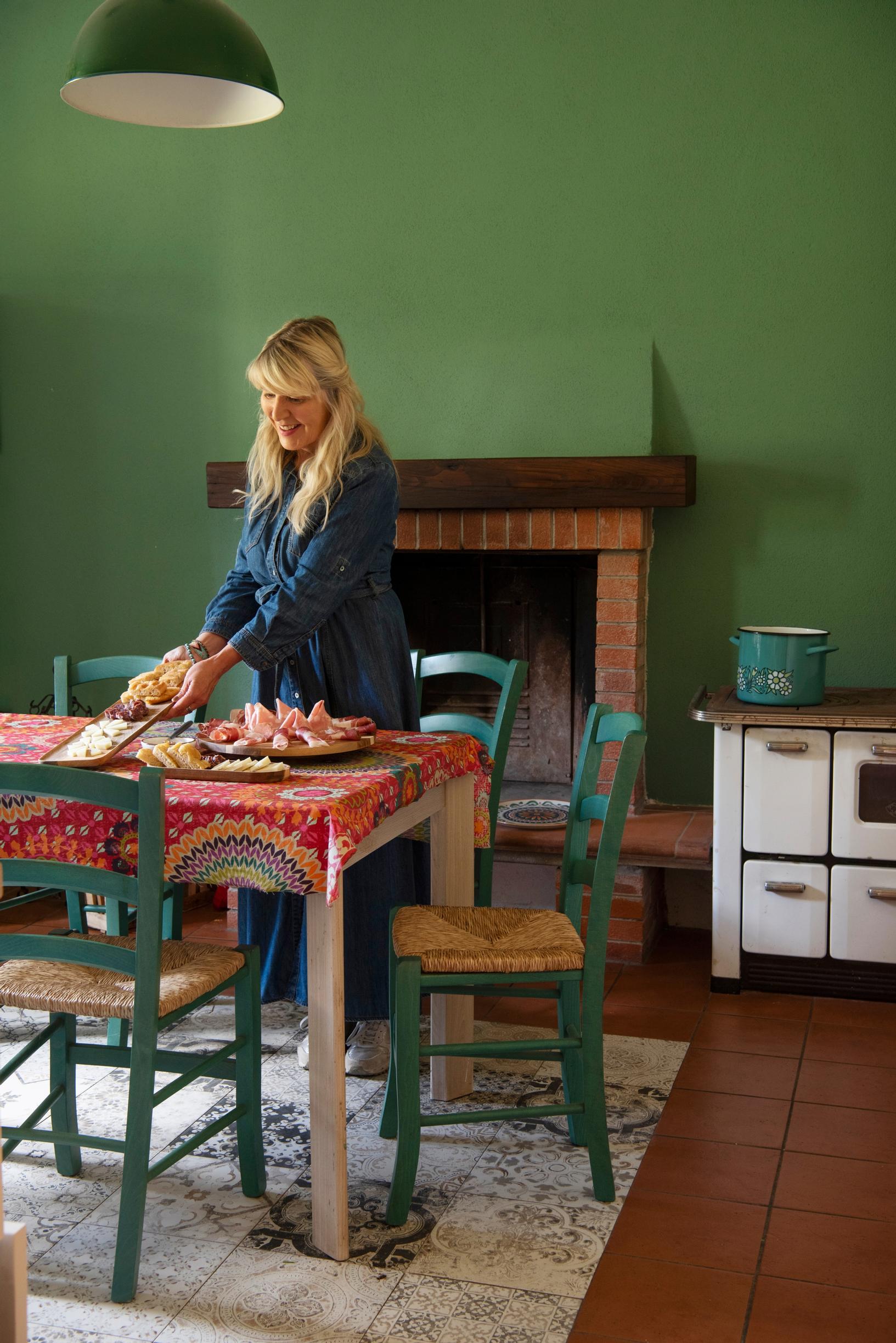 Keittiön valkoinen seinä muuttui Eijan käsissä vihreäksi. Tuolit, pöytä ja pöytäliina ovat edellisten asukkaiden perua.