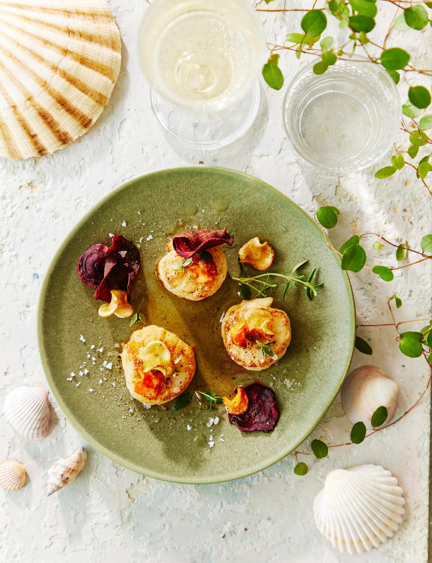 Kypsennä juureslastuja 225-asteisessa uunissa kymmenen minuuttia, niin saat niistä ihanan rapean lisukkeen kampasimpukoille.