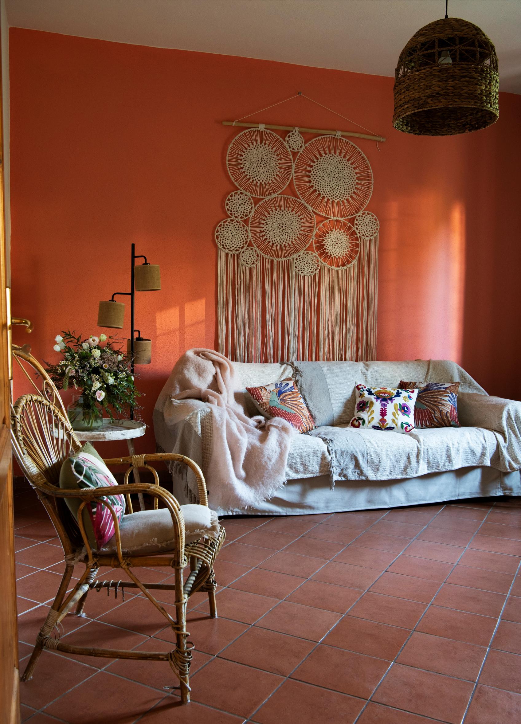 Eija valitsi olohuoneeseen persikan sävyisen maalin terrakottalaatan pariksi. Ikeasta hankittua sohvaa somistavat ranskalaisen Maisons du Monden peitot, värikkäät tyynyt ja äidiltä peritty Balmuirin huopa.