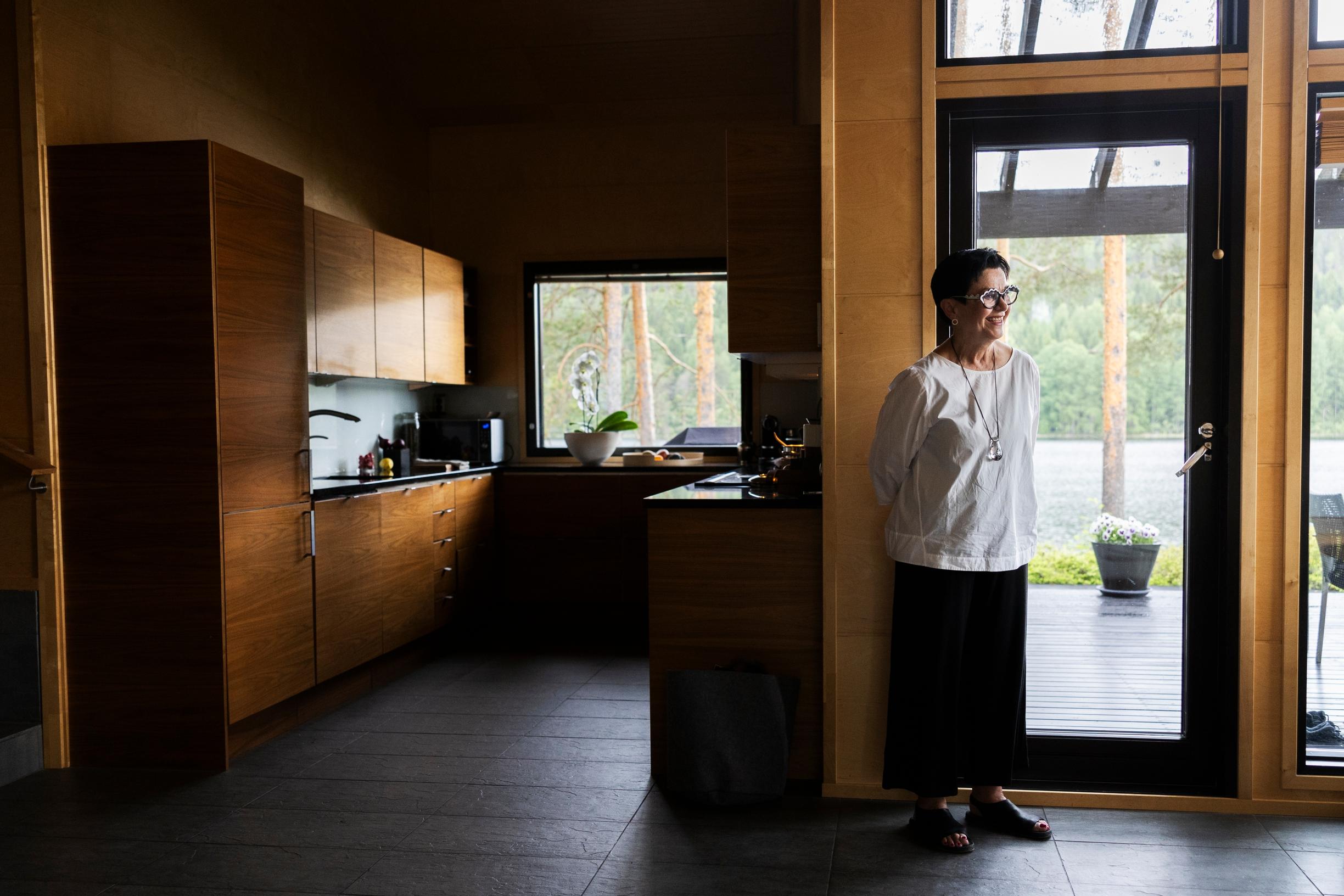 U-keittiö on omassa nurkassaan. Kaappien pähkinäpuu sopii mäntyjen rungon väriin. Vankka tummanharmaa luonnonkivilattia rauhoittaa.