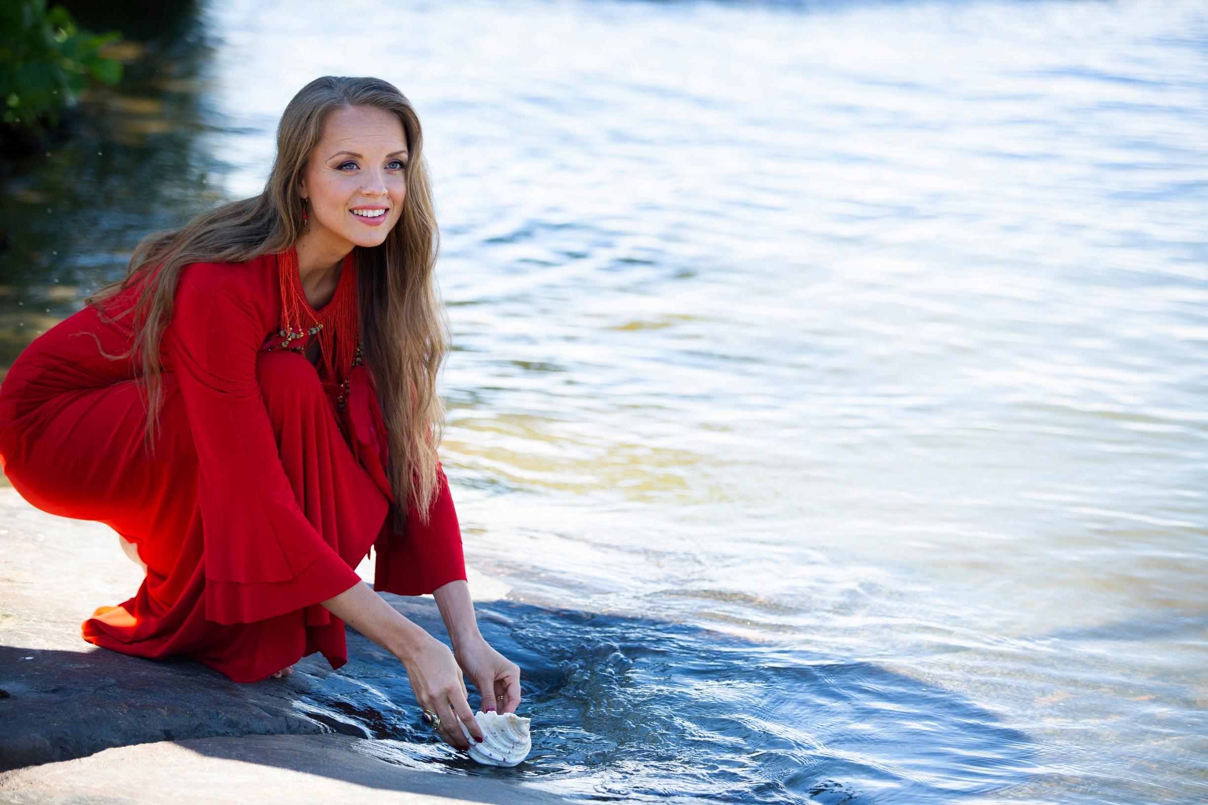 Kirsi rannalla simpukka kädessään