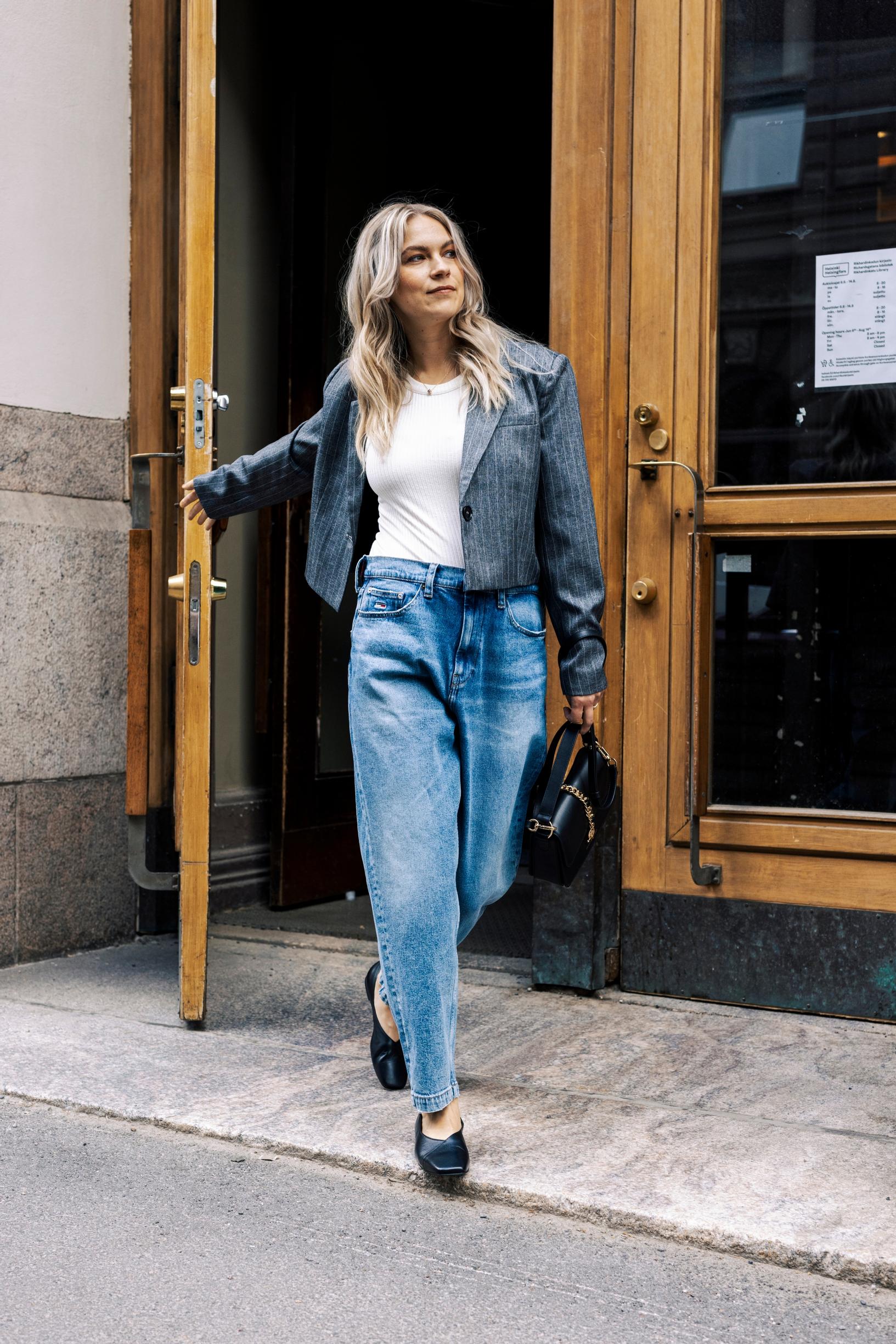 Emmi-Liia Sjöholm, joka on pukeutunut löysiin farkkuihin ja bleiseriin.