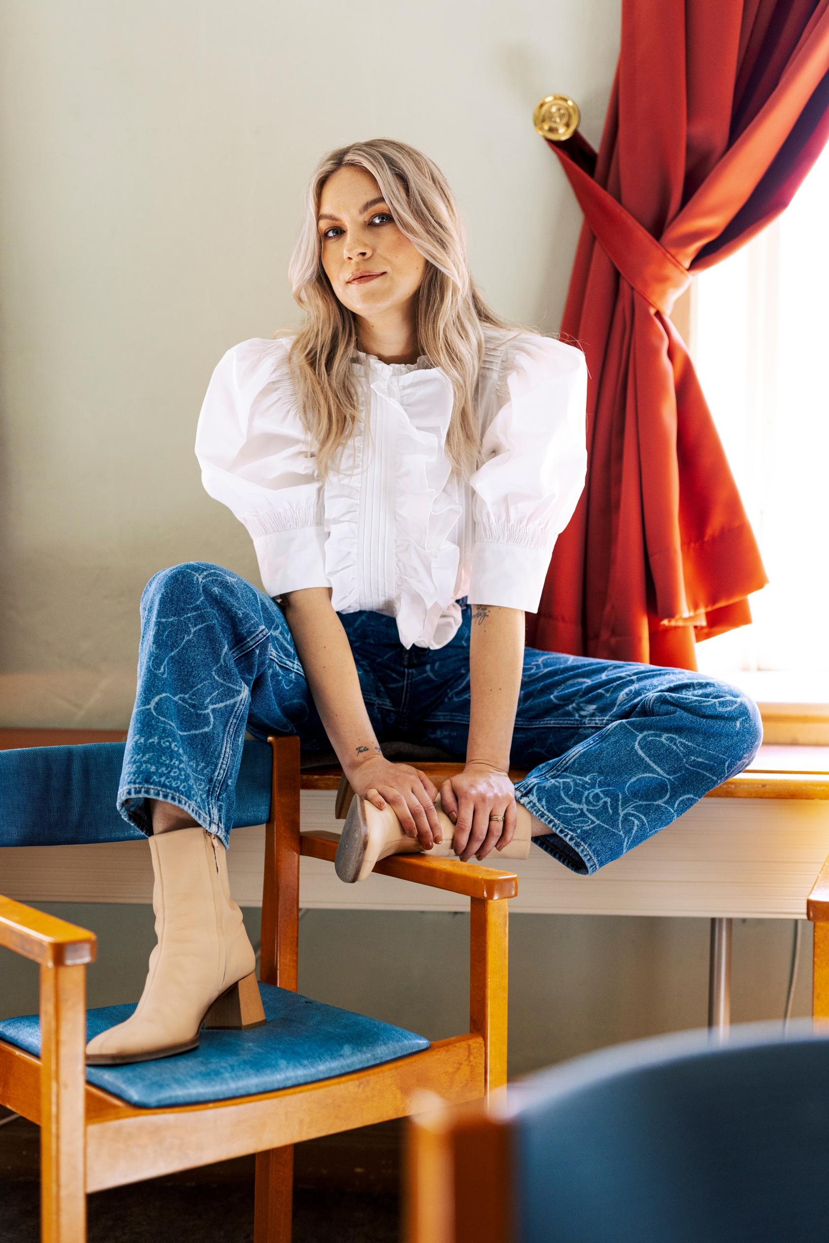 Emmi-Liia Sjöholmin yllä on röyhelöinen valkoinen paita.