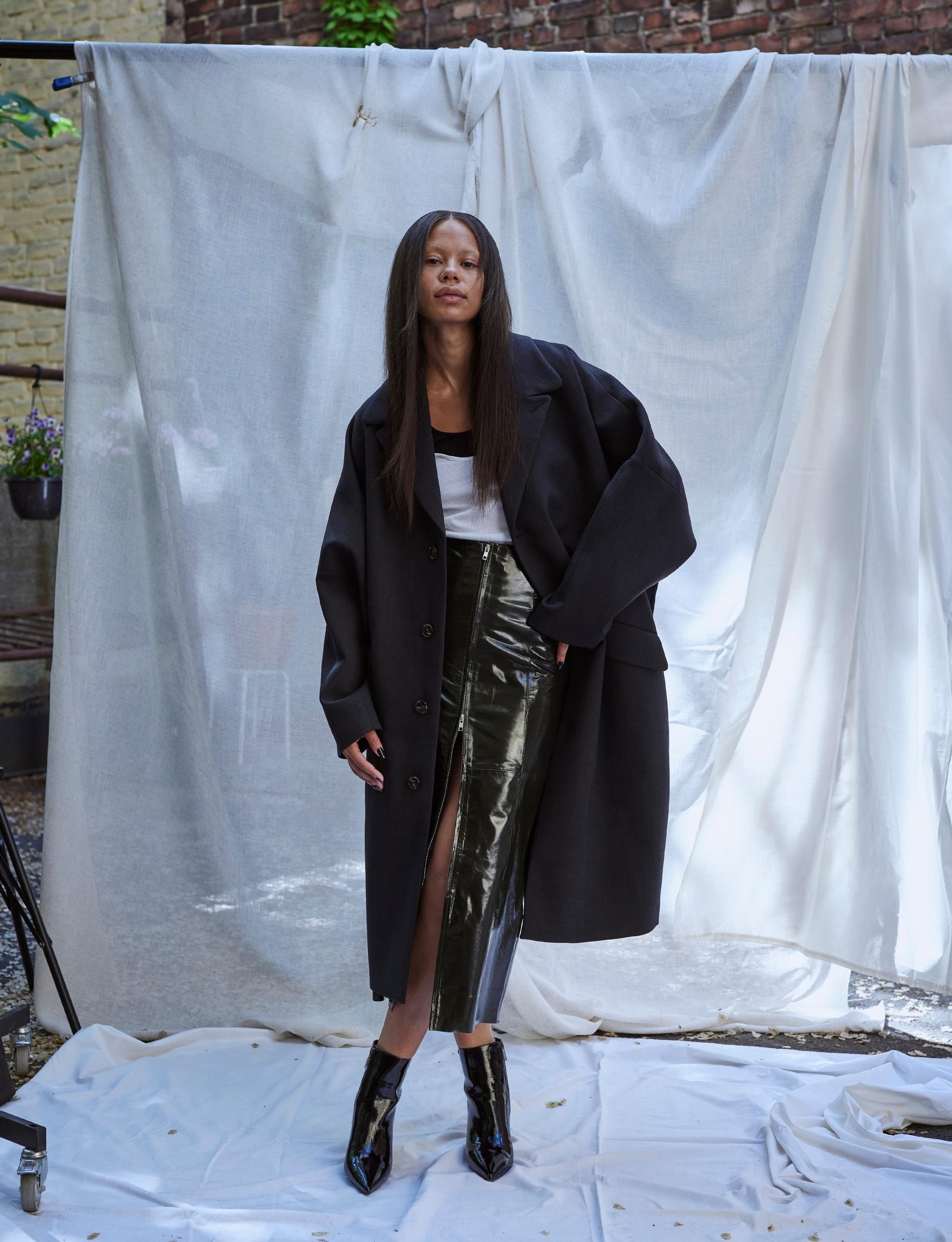 Takki 1 300 e, MM6/Zalando. Musta toppi 70 e, By Malene Birger / Stockmann. Valkoinen toppi 19 e, Arket. Nahkahame 430 e, Gestuz. Nilkkurit 225 e, Michael Kors / Stockmann.