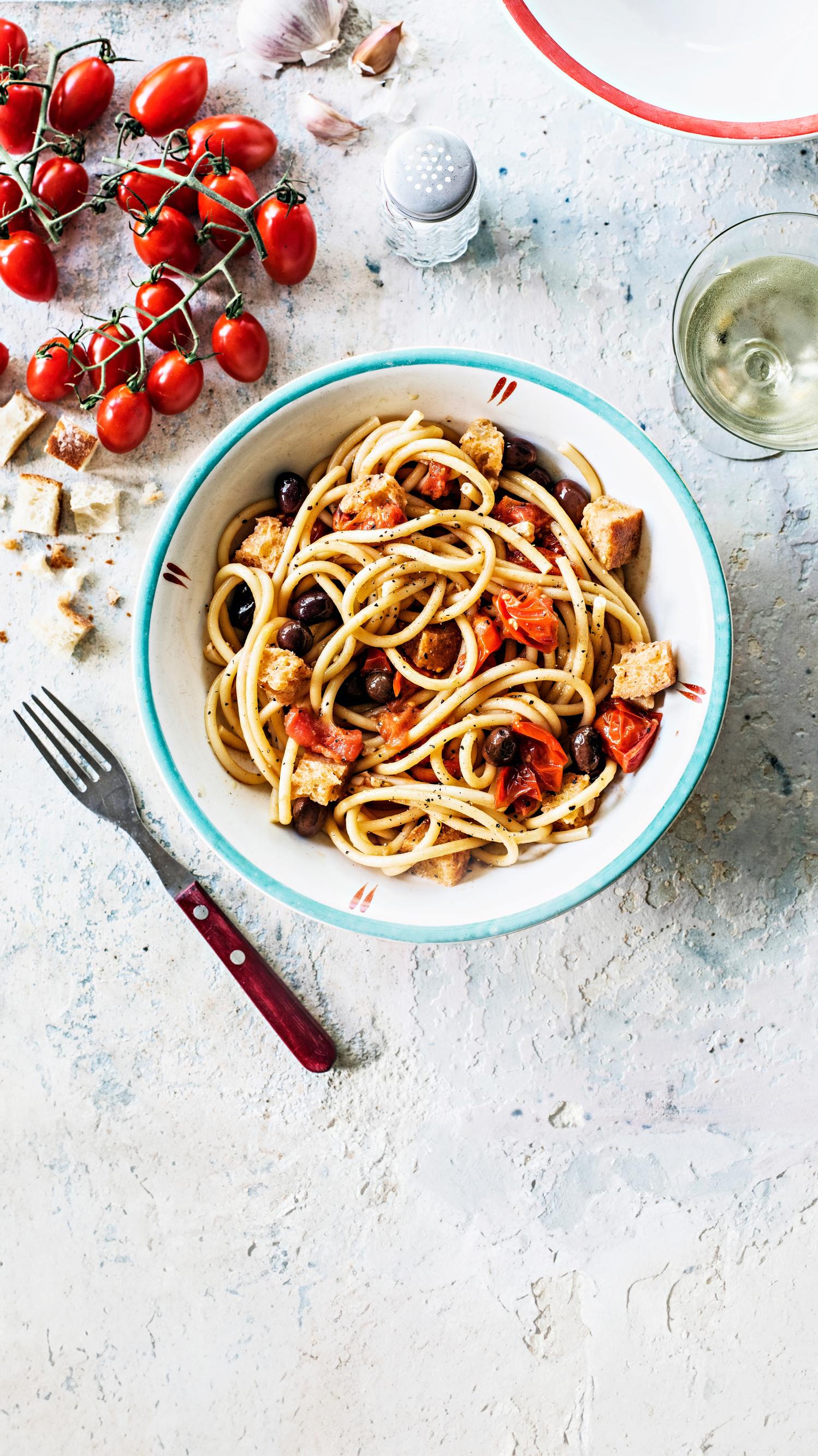 Herkullinen pasta saa makua tomaateista, oliiveista, anjoviksista ja leipälaatikon kuivista kantapaloista.