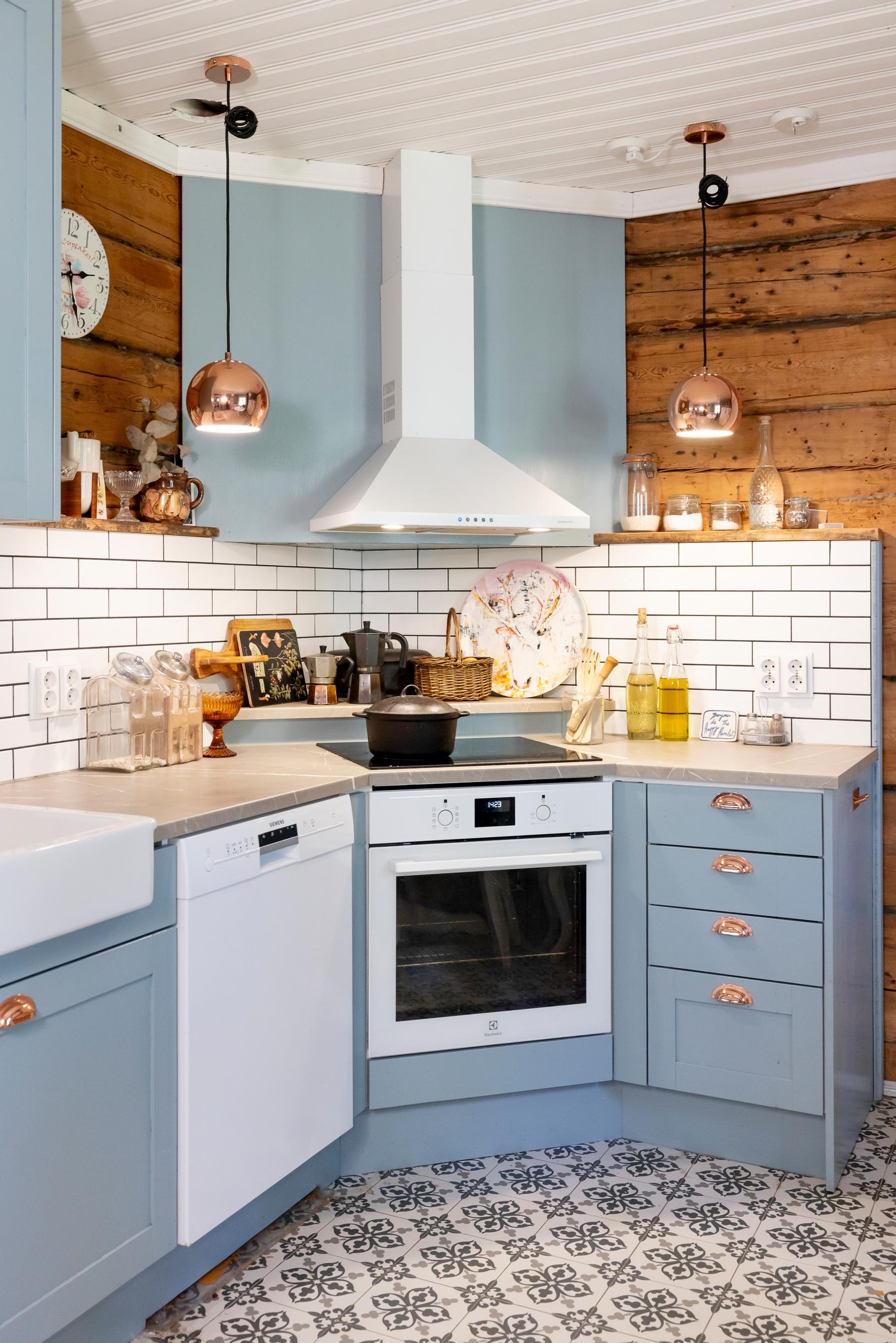 Inari rakastaa kokata isolle porukalle. Emmi-Liinu Sutisen suunnittelemassa keittiössä on vanhahtavan siniset kaapit, sävy on Virtasen maalien Dalskär.