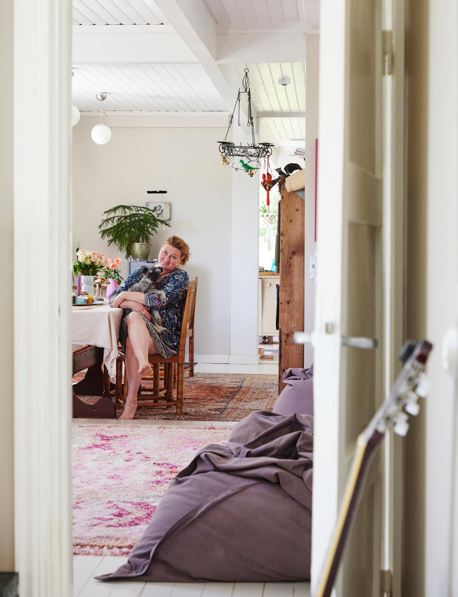 Ria Katajan sylissä viihtyy kääpiösnautseri Ujo-Rohkea Kataja, 13. Alakerran tupamaisessa tilassa yhdistyvät olohuone ja ruokailutila.