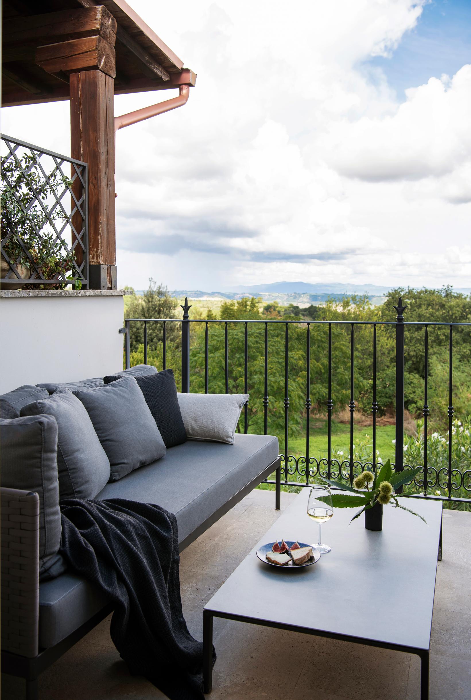 Talon takana avautuu näkymä Apenniinien vuoristoon. Sohva on italialaisen Rodan ja pöytä Andreu Worldin. Carolan piirtämät terassin kaiteet on tehnyt paikallinen seppä.