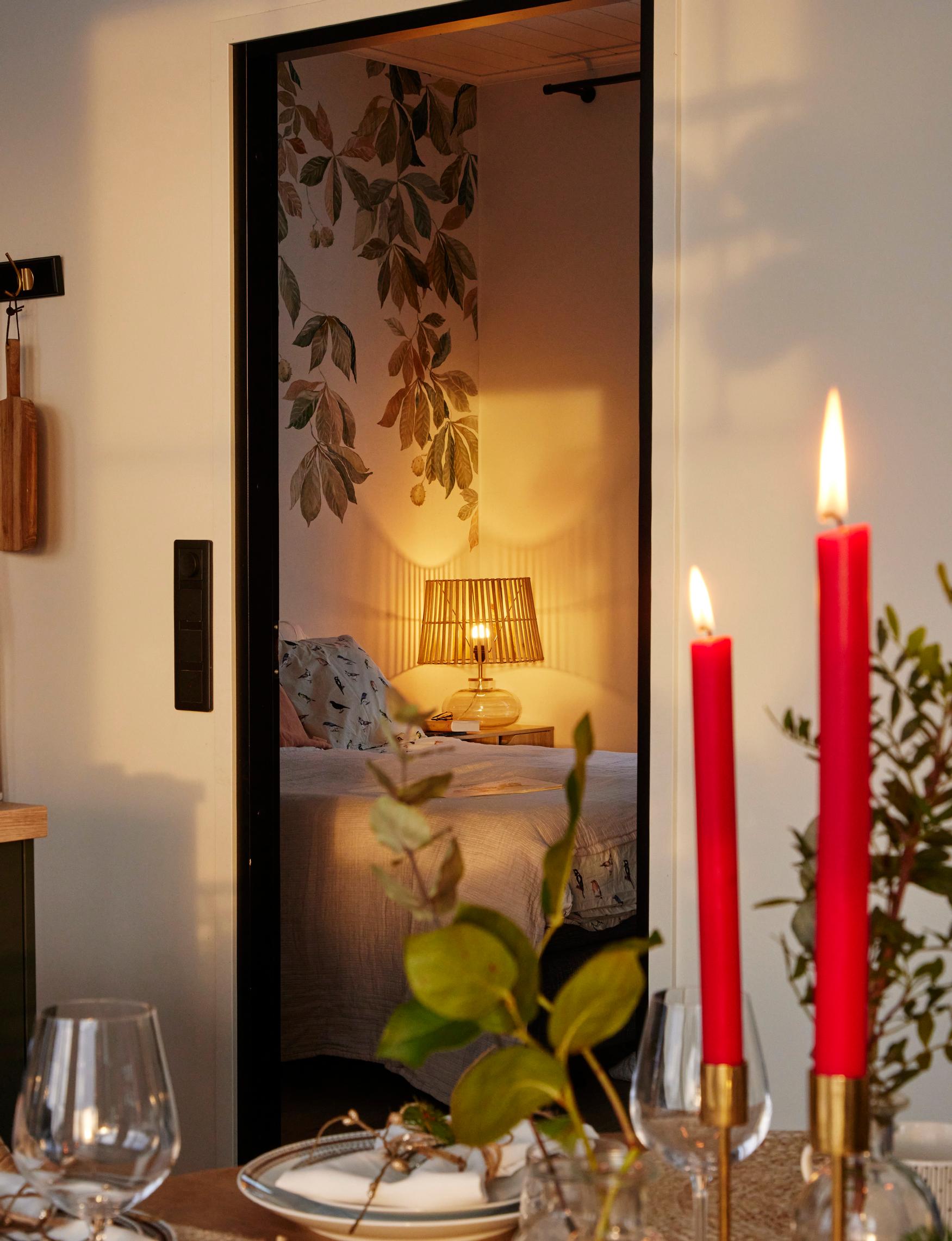 Hannelen ja Markuksen makuuhuoneeseen valittiin tapetiksi Sandbergin Kastanja Garden Green. Makuuhuoneessa Hannele lukee kirjoja.