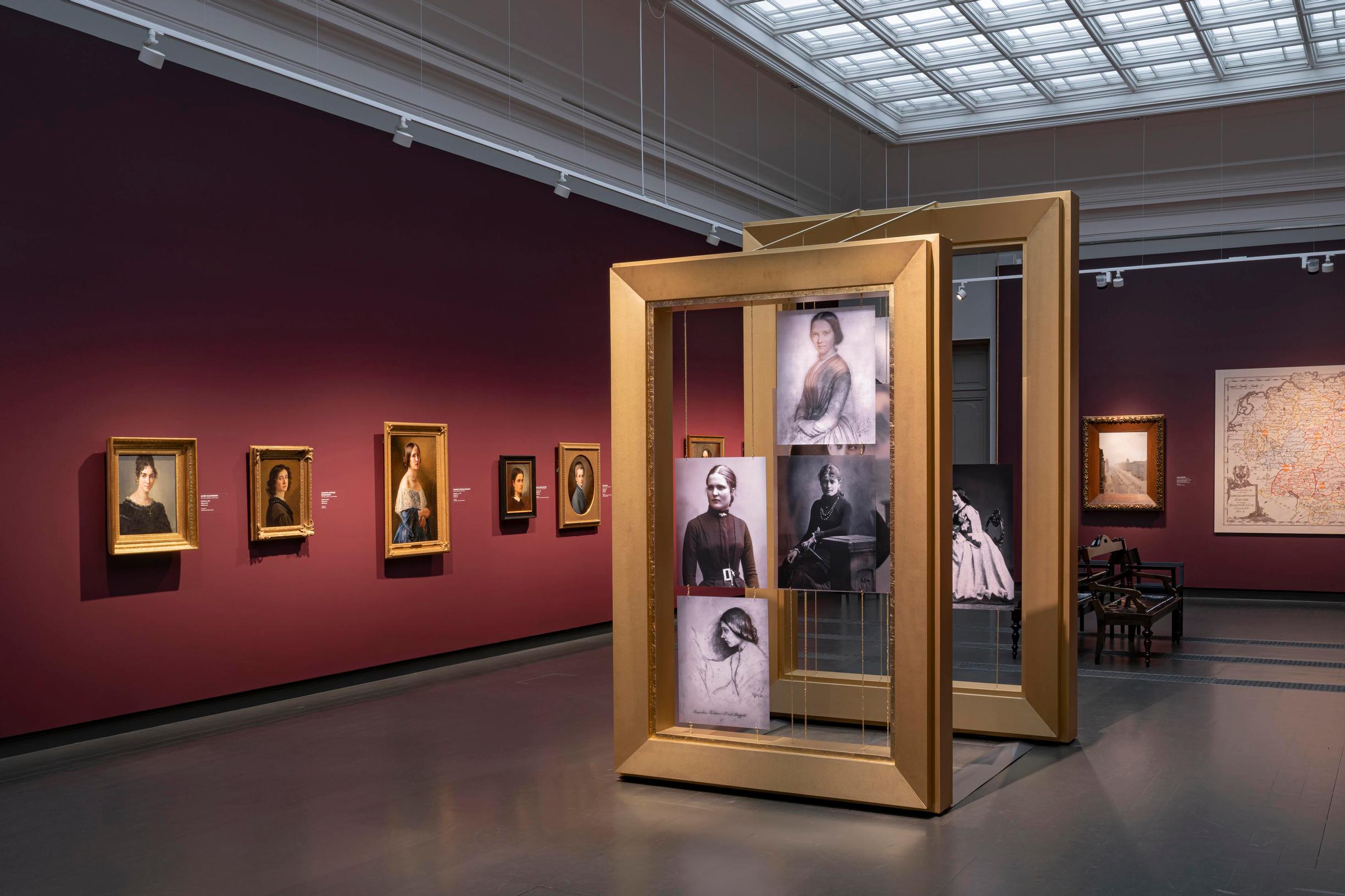 Näkymä näyttelysalista, seinillä naistaiteilijoiden muotokuvia