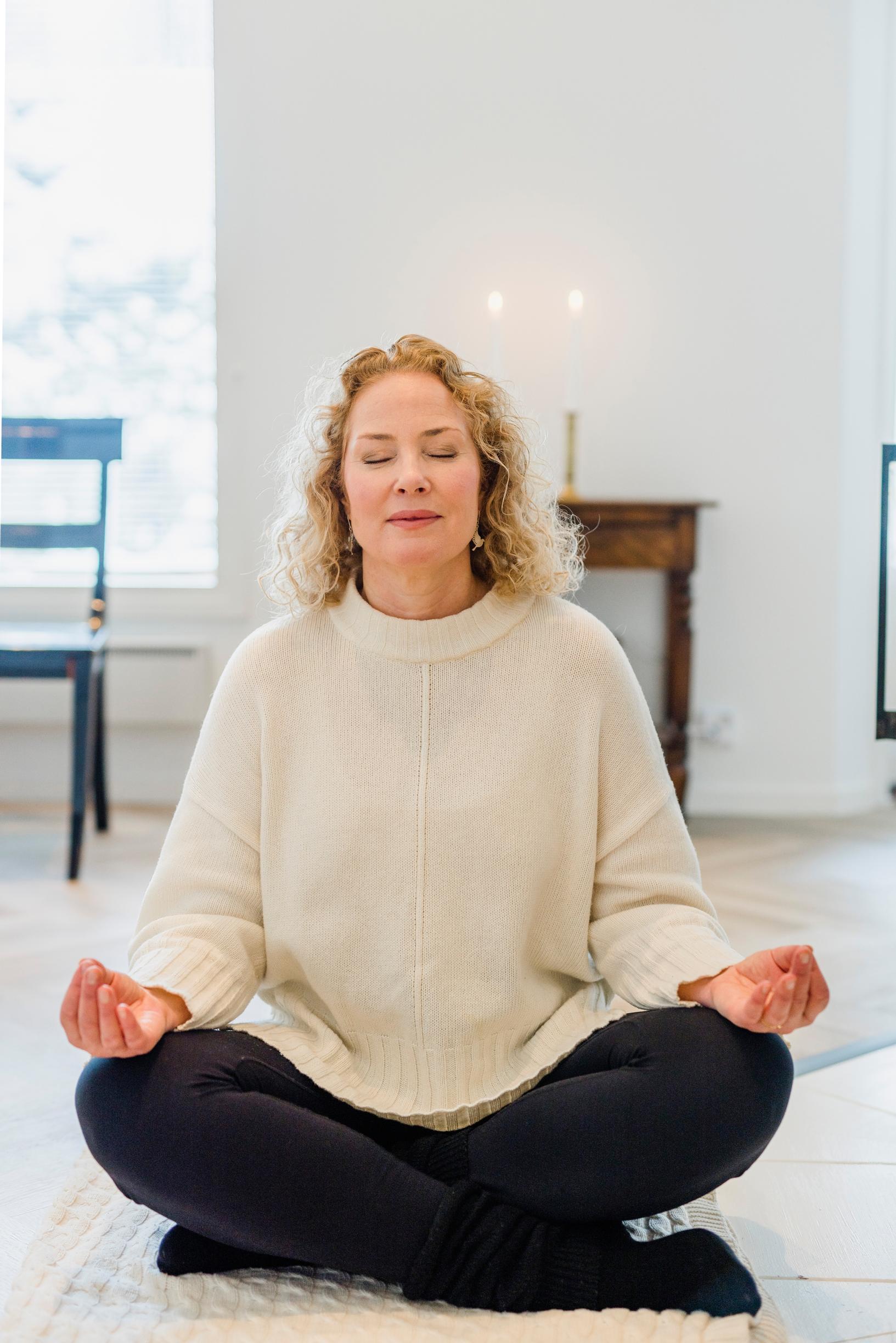 Näyttelijä Miia Nuutila meditoimassa lootusasennossa.