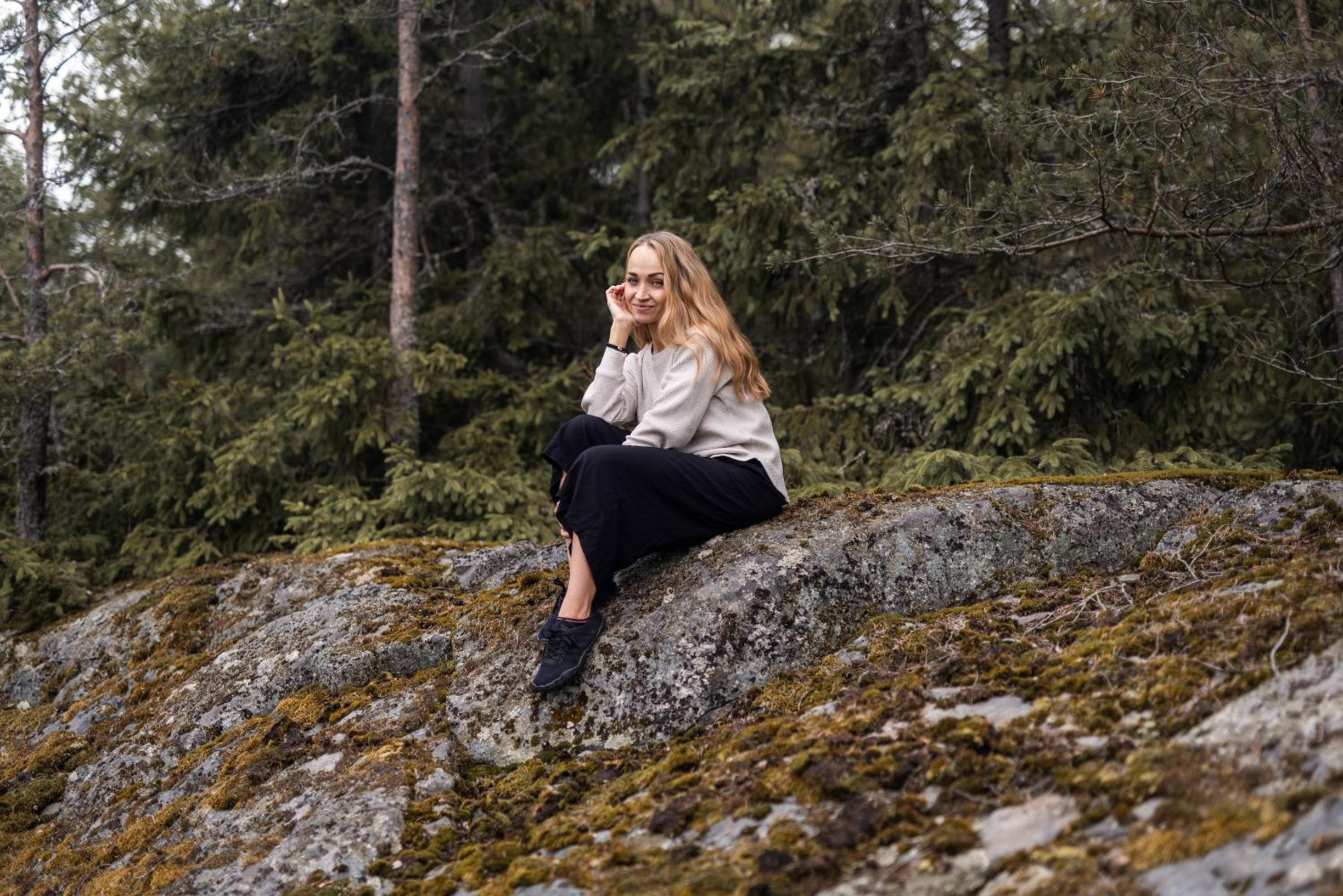 Jenni istuu kalliolla