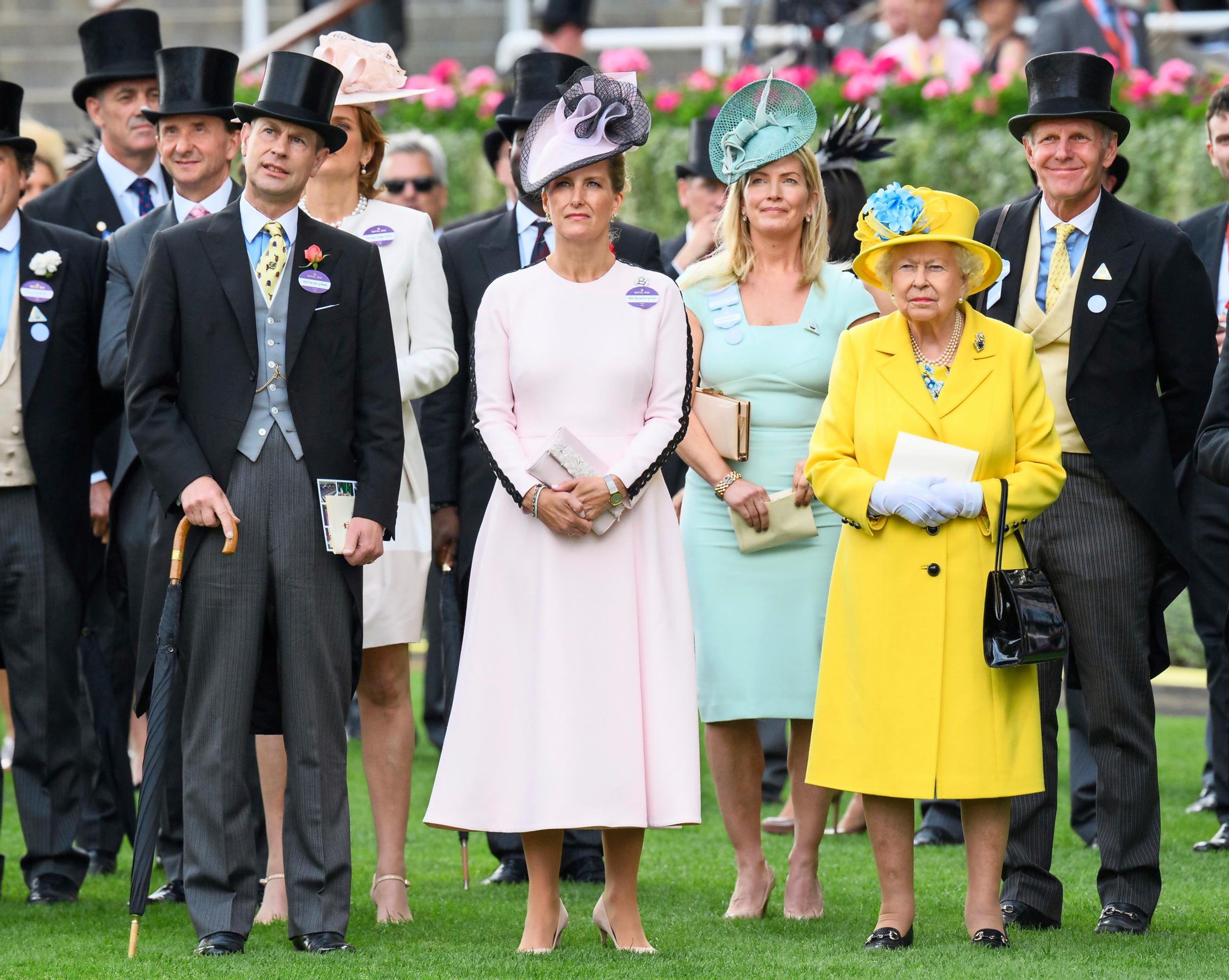 Elisabet II pukeutuu mielellään värikkäisiin vaatteisiin, jotta hän erottuu väkijoukoissa. Prinssi Edward, Wessexin jaarli (vas.) on Britannian kuningattaren nuorin lapsi. Keskellä seisoo Edwardin puoliso, Wessexin kreivitär Sophie.